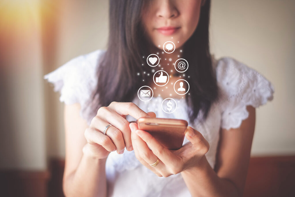 Woman using mobile phone for checking social media and success of business.