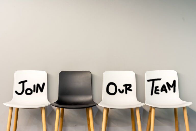 Job recruiting advertisement represented by 'JOIN OUR TEAM' texts on the chairs. One chair is colored differently to represent the hiring position to be recruited and filled.