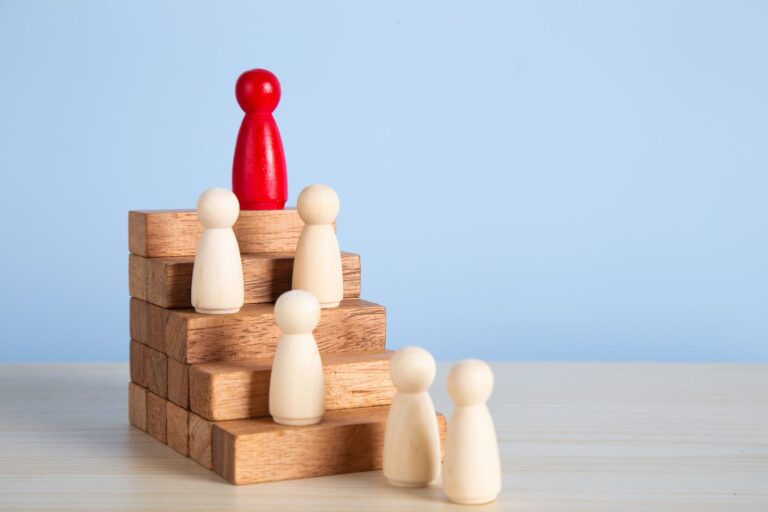 Wooden people figures on top of wooden blocks